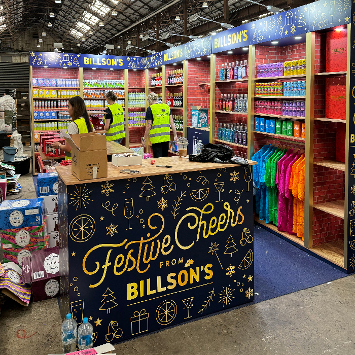 Billson's Festive Cheers pop-up with red brick-print walls and timber shelving