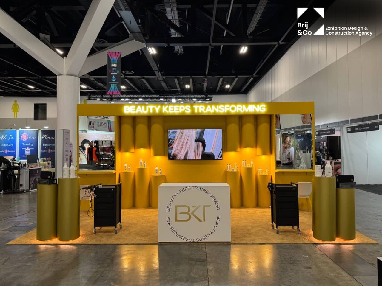 BKT exhibition stand with a yellow backwall and gold display podiums
