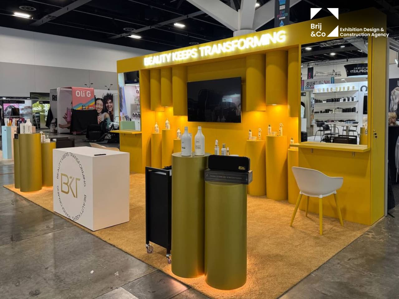 BKT Beauty Keeps Transforming exhibition stand with a yellow backwall and gold podiums