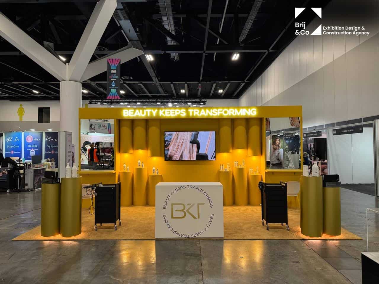 BKT Beauty Keeps Transforming exhibition stand with gold podiums and product displays