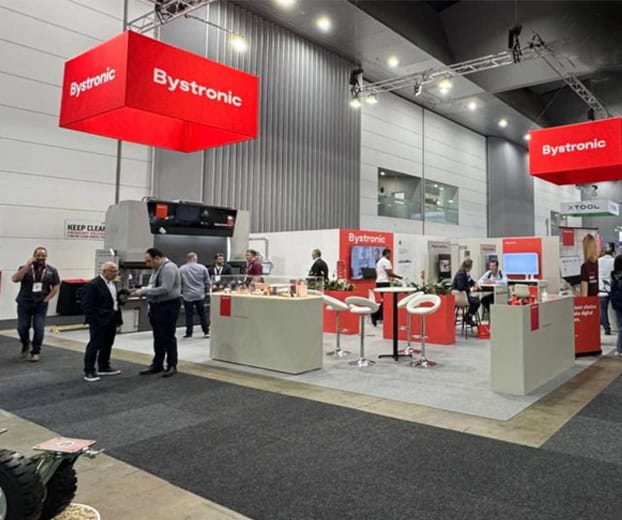 Bystronic exhibition stand with red hanging banners, built by Brij & Co