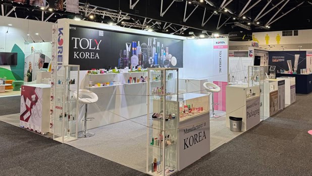 Korea pavilion booths with glass shelving and K-beauty brand graphics