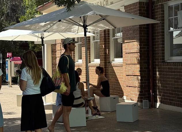 Outdoor event pop-up with umbrellas and white cube seating