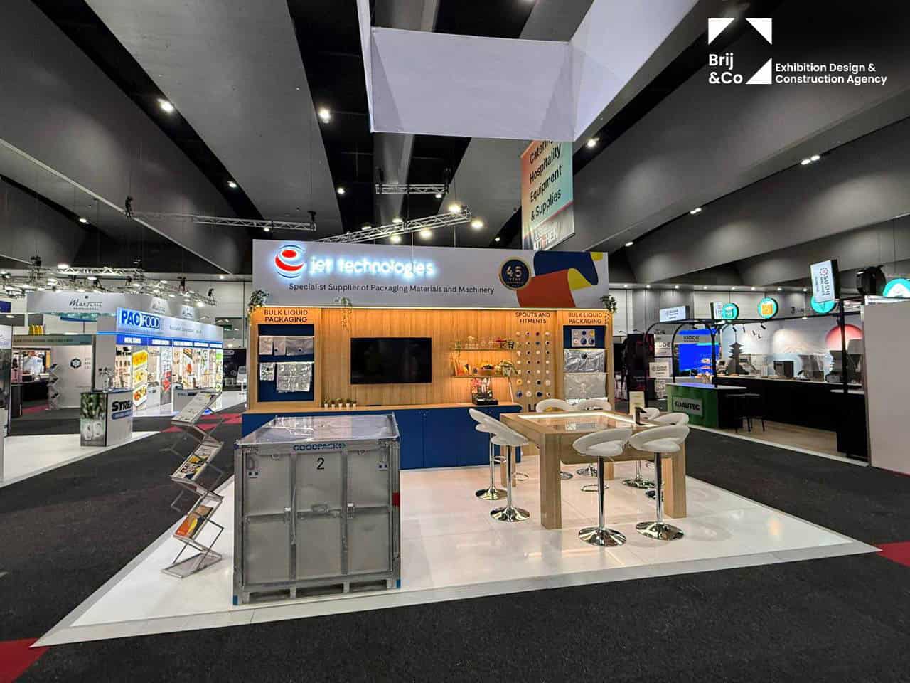 Jet Technologies exhibition stand with timber shelving, screens and a bar-height table