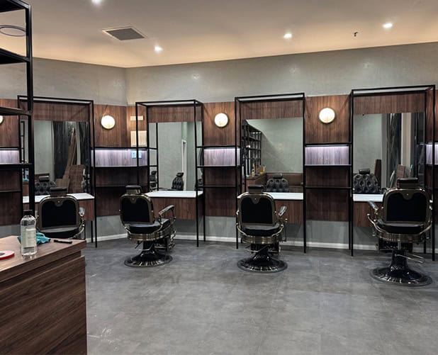Barbershop fit-out with mirrors, black steel frames and round wall lights