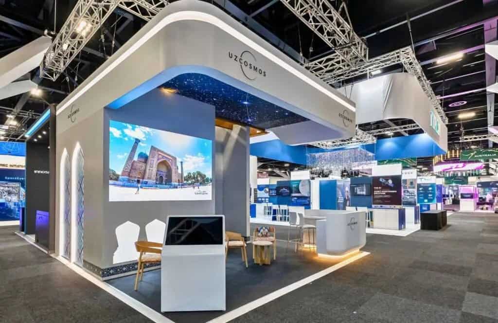 Uzbekspace exhibition stand with curved white walls and a large screen