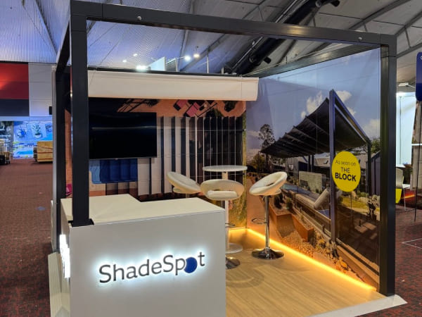 ShadeSpot stand at the Pool and Spa Expo with a lit counter and bar stools