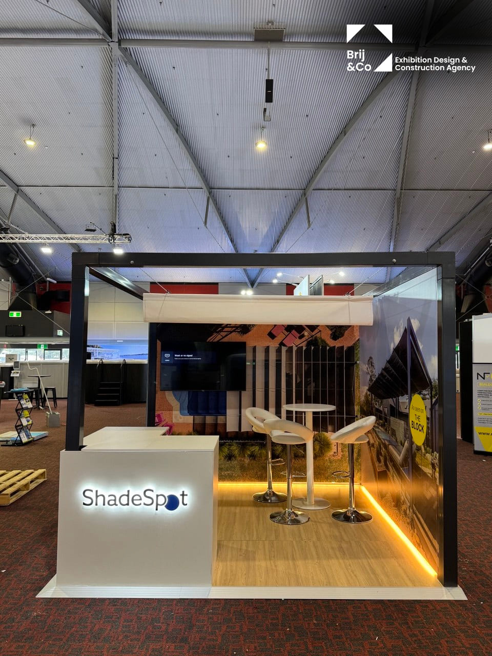 ShadeSpot exhibition stand with a black frame, lit counter and timber floor