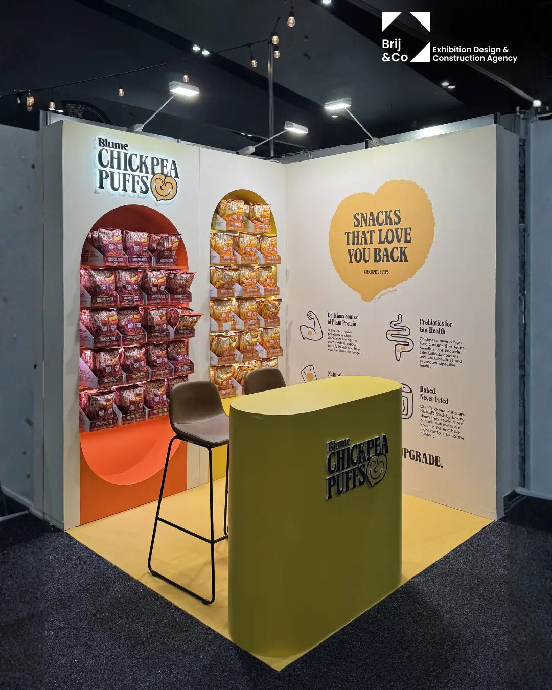 Blume Chickpea Puffs stand with arched product displays and a yellow counter