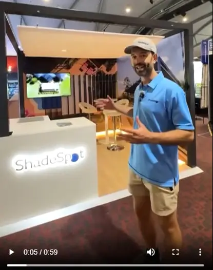 ShadeSpot stand video still with a presenter beside the lit counter
