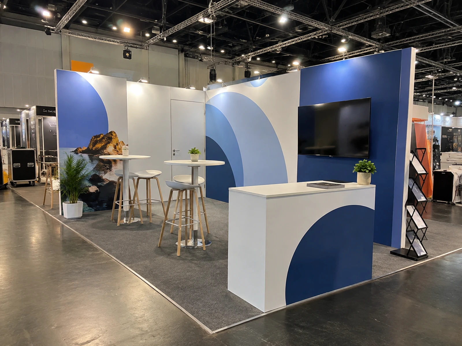 Hire bar tables and white stools set up on an exhibition stand before doors open