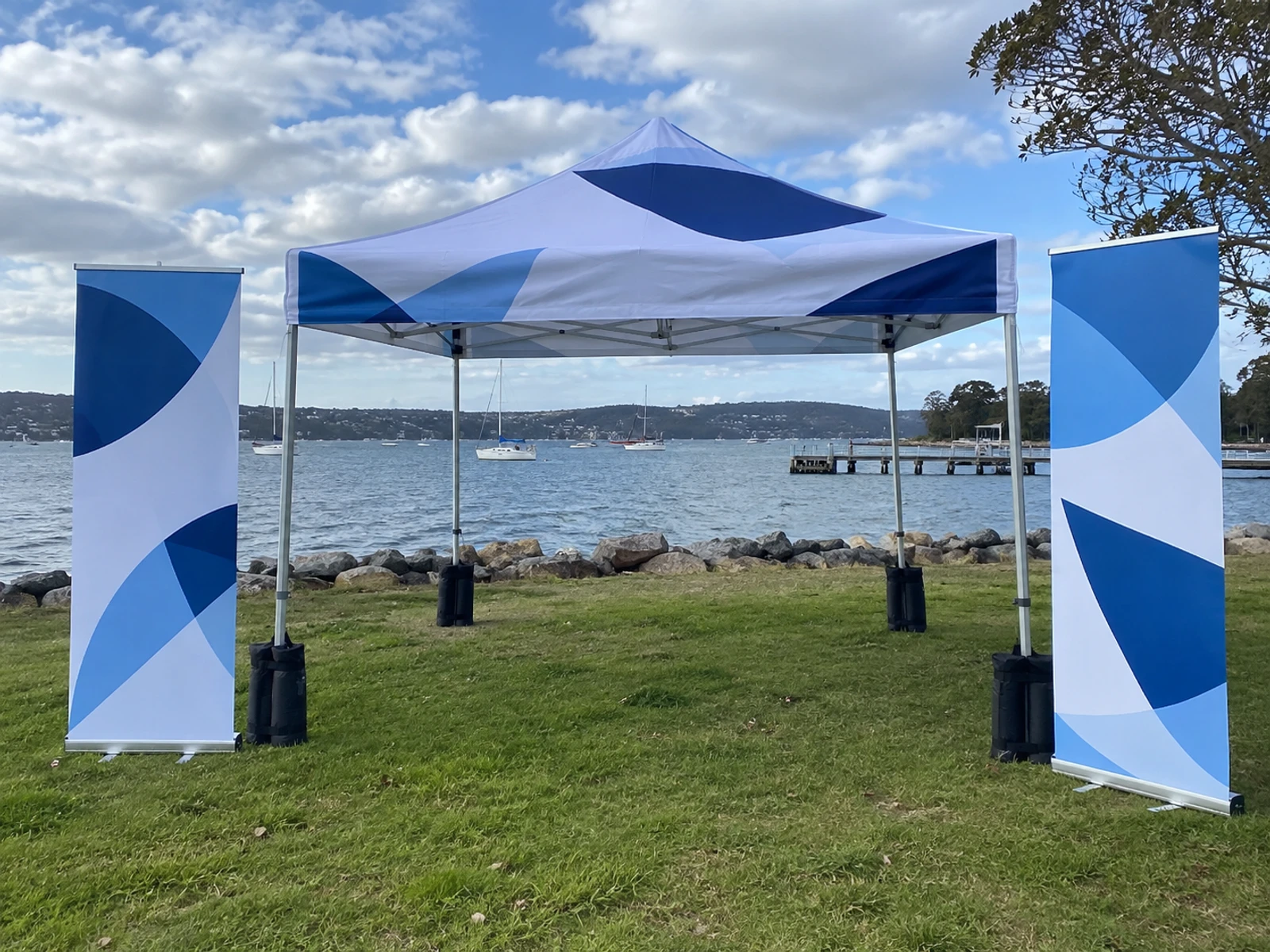 Weighted outdoor banners and a branded marquee set up on grass
