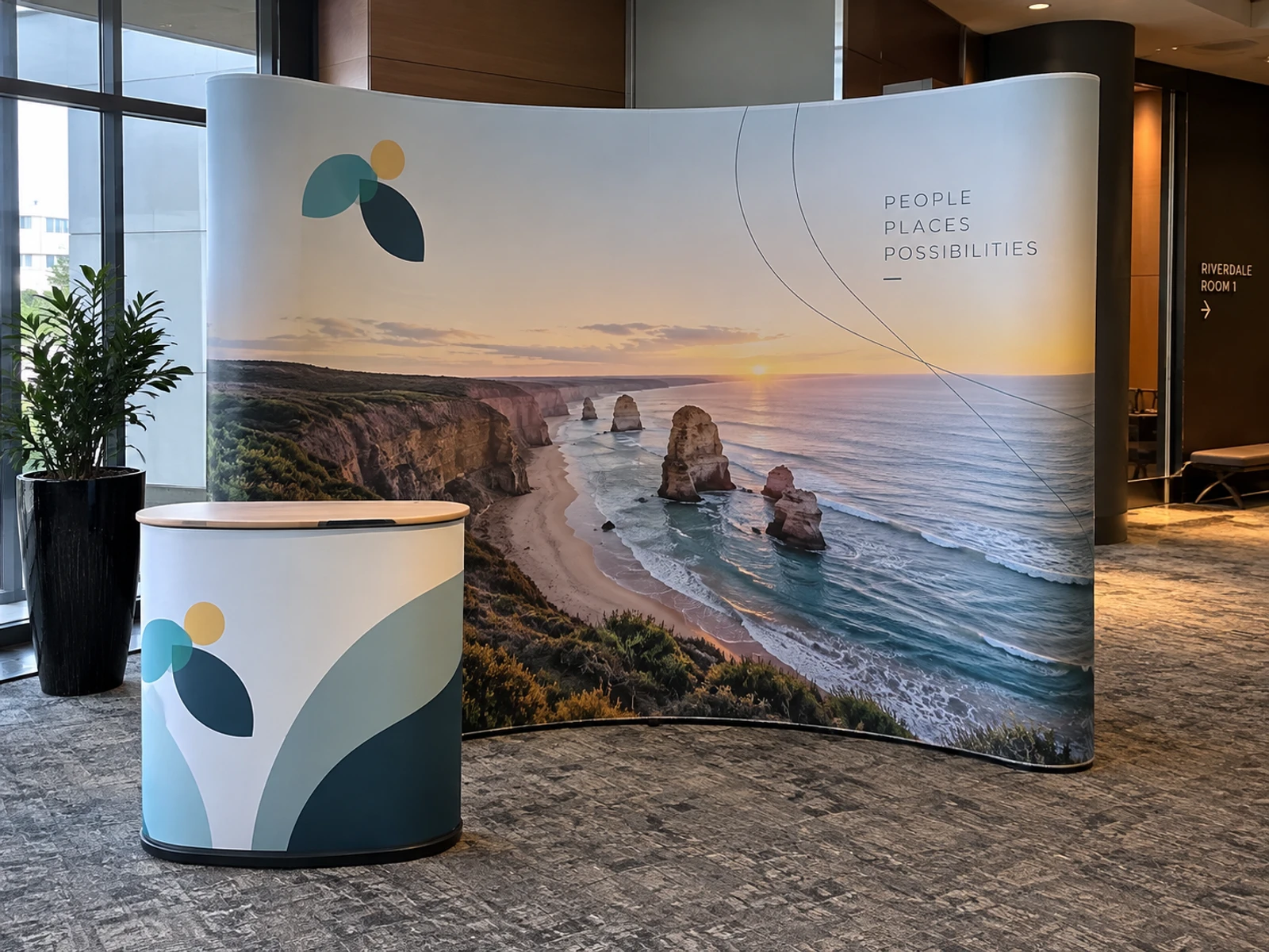 Curved fabric pop-up display wall with a matching printed counter at a conference