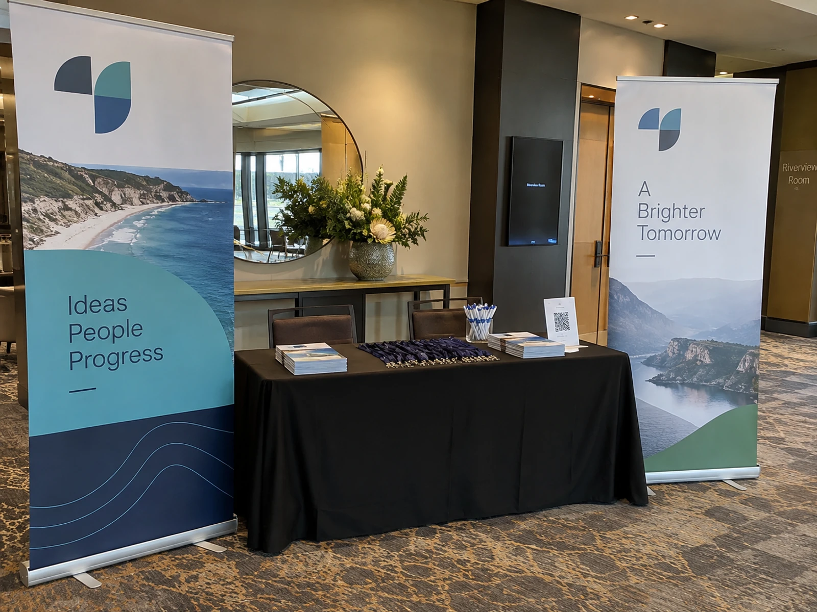 Two pull-up banners standing beside a conference registration desk