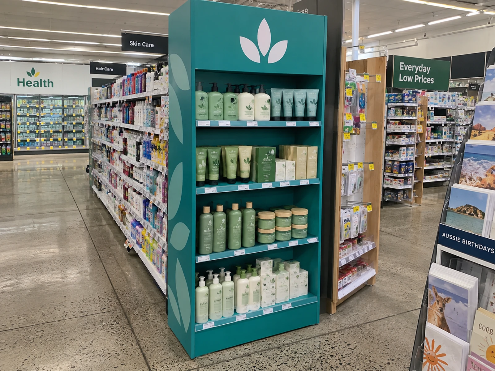 Freestanding floor display unit with four shelves of product at the end of a retail aisle